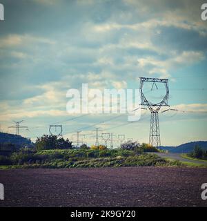 Hochspannungsmasten - Blauer Himmel mit Wolken und Sonne in der Natur. Konzept für Technologie und Industrie. Weiter steigende Strom- und Energiepreise - die Stockfoto