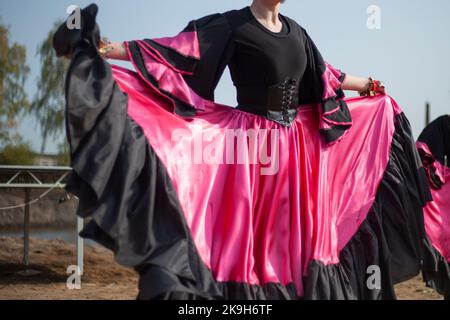 Gipsy tanzt in hellen Kleidern. Mädchen tanzen auf der Straße spanischen Tanz. In leuchtender Qualität. Tanzbewegungen. Stockfoto