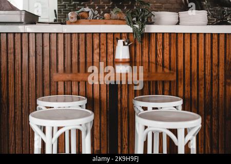 Holztisch, Besteck und Hocker in einem Restaurant Stockfoto