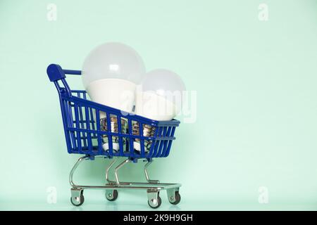 Zwei LED-Glühbirnen liegen in einem Korb aus einem Supermarkt auf einem isolierten Hintergrund, der Preis für Strom, kaufen Licht Stockfoto