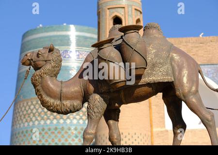 Khiva Usbekistan - Denkmal der Kamelfiguren der alten Seidenstraßen auf der UNESCO-Stätte IInchon Qala mit dem Minarett von Kalta im Hintergrund Stockfoto