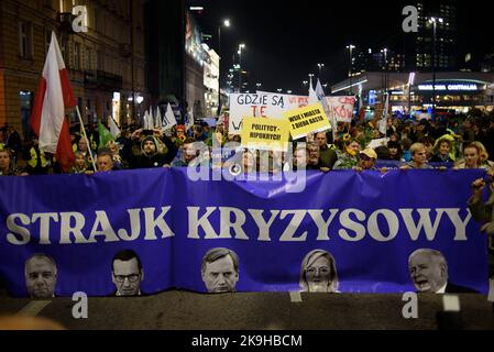 Warschau, Warschau, Polen. 28. Oktober 2022. Die Demonstranten tragen während eines regierungsfeindlichen Protestes am 28 2022. Oktober in Warschau, Polen, ein Transparent mit der Aufschrift „„Krisenschlag“. Hunderte von Menschen versammelten sich, um gegen steigende Energiepreise und die Abhängigkeit von fossilen Brennstoffen aus Russland zu protestieren. Die Demonstranten beschuldigen Politiker für die Unfähigkeit, eine sofortige Lösung für Klima-, Lebensmittel- und Energiekrisen zu finden und forderten einen schnelleren Übergang zu erneuerbaren Energiequellen. (Bild: © Aleksander Kalka/ZUMA Press Wire) Stockfoto