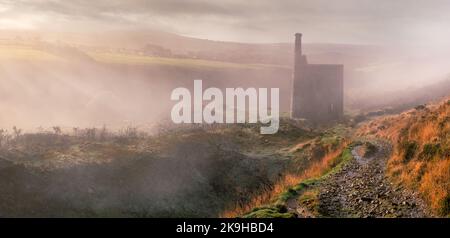 Der frühe Morgennebel schmilzt langsam ab, während die Sonne durch die tief liegende Wolke im Tal nahe Mary Tavy und den Fußweg hinunter nach W bricht Stockfoto