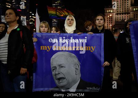 Warschau, Warschau, Polen. 28. Oktober 2022. Die Demonstranten halten ein Transparent mit der Darstellung des Führers der Regierungspartei PiS (Recht und Gerechtigkeit) und der Aufschrift „Er hat Spaß, wir frieren ein“ während eines regierungsfeindlichen Protestes am 28 2022. Oktober in Warschau, Polen. Hunderte von Menschen versammelten sich, um gegen steigende Energiepreise und die Abhängigkeit von fossilen Brennstoffen aus Russland zu protestieren. Die Demonstranten beschuldigen Politiker für die Unfähigkeit, eine sofortige Lösung für Klima-, Lebensmittel- und Energiekrisen zu finden und forderten einen schnelleren Übergang zu erneuerbaren Energiequellen. (Bild: © Aleksander Kalka/ZUMA Press Wire) Stockfoto