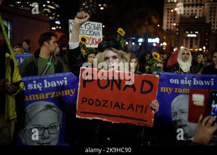 Warschau, Warschau, Polen. 28. Oktober 2022. Eine Frau erhebt ihre Faust, während sie während eines regierungsfeindlichen Protestes am 28 2022. Oktober in Warschau, Polen, ein Schild mit der Aufschrift „über den Divisionen“ hält. Hunderte von Menschen versammelten sich, um gegen steigende Energiepreise und die Abhängigkeit von fossilen Brennstoffen aus Russland zu protestieren. Die Demonstranten beschuldigen Politiker für die Unfähigkeit, eine sofortige Lösung für Klima-, Lebensmittel- und Energiekrisen zu finden und forderten einen schnelleren Übergang zu erneuerbaren Energiequellen. (Bild: © Aleksander Kalka/ZUMA Press Wire) Stockfoto
