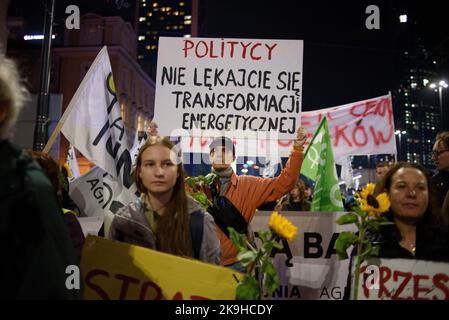 Warschau, Warschau, Polen. 28. Oktober 2022. Die Demonstranten halten Sonnenblumen und Schilder, unter denen die Aufschrift „Politiker haben keine Angst vor energischer Transformation“ während eines regierungsfeindlichen Protestes am 28 2022. Oktober in Warschau, Polen, zu lesen ist. Hunderte von Menschen versammelten sich, um gegen steigende Energiepreise und die Abhängigkeit von fossilen Brennstoffen aus Russland zu protestieren. Die Demonstranten beschuldigen Politiker für die Unfähigkeit, eine sofortige Lösung für Klima-, Lebensmittel- und Energiekrisen zu finden und forderten einen schnelleren Übergang zu erneuerbaren Energiequellen. (Bild: © Aleksander Kalka/ZUMA Press Wire) Stockfoto