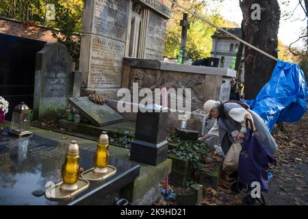 Warschau, Mazowieckie, Polen. 27. Oktober 2022. Eine ältere Frau sah, wie sie auf dem historischen Powazki Friedhof ein Grab reinigte. Der Allerheiligste Tag, der am 1.. November stattfindet, ist ein Feiertag in Polen und einer der wichtigsten katholischen Feiertage im Laufe des Jahres. Diejenigen, die ihre Angehörigen verloren haben, gehen auf die Friedhofs, um den Toten ihre Achtung zu erweisen. Sie brennen Kerzen auf den Gräbern und bringen Blumen. Es wird manchmal auch als der Tag der Erinnerung an die, die gegangen sind, bezeichnet. (Bild: © Attila Husejnow/SOPA Images via ZUMA Press Wire) Stockfoto