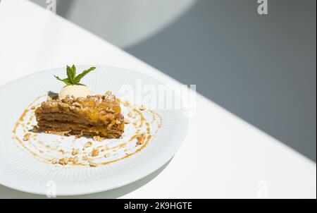 Walnusskuchen mit Puddingcreme und Marmelade, serviert mit einem Vanilleeis, der bereit ist, an einem Restauranttisch zu essen Stockfoto