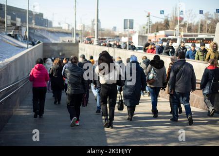 Viele Leute laufen durch die Stadt. Männer und Frauen auf der Straße. Die Bürger gehen in Menschenmenge. Viel Verkehr. Stockfoto