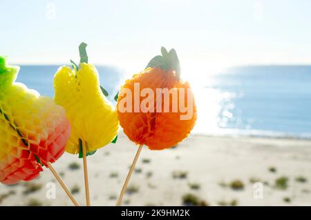 Farbenfrohe Cocktaildekorationen auf dem Hintergrund des blauen Himmels und des Meeres, Sandstrand am sonnigen Sommertag. Konzept Zeichen Symbol für Urlaub Tourismus Reise Entspannung Urlaub Erholung Feier Reisen Tropen Stockfoto