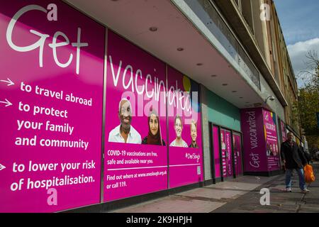 Slough, Großbritannien. 28.. Oktober 2022. Ein Mitglied der öffentlichen Pässe wird geimpft Public Health Leitseivertafeln. Die Boards wurden vom Slough Borough Council als Teil der OneSlough-Initiative erstellt, die im März 2020 ins Leben gerufen wurde, um die Ressourcen und Fähigkeiten des freiwilligen Sektors und der Wirtschaftssektoren mit Glaubensgemeinschaften und dem Slough Borough Council zu kombinieren, um den Bewohnern von Slough während der Pandemie Covid-19 wichtige Dienste zu leisten. Kredit: Mark Kerrison/Alamy Live Nachrichten Stockfoto