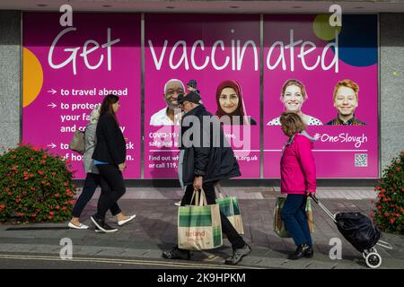 Slough, Großbritannien. 28.. Oktober 2022. Die Mitglieder des öffentlichen Passes werden geimpft Public Health Leitseivertafeln. Die Boards wurden vom Slough Borough Council als Teil der OneSlough-Initiative erstellt, die im März 2020 ins Leben gerufen wurde, um die Ressourcen und Fähigkeiten des freiwilligen Sektors und der Wirtschaftssektoren mit Glaubensgemeinschaften und dem Slough Borough Council zu kombinieren, um den Bewohnern von Slough während der Pandemie Covid-19 wichtige Dienste zu leisten. Kredit: Mark Kerrison/Alamy Live Nachrichten Stockfoto