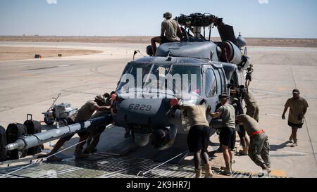 Flieger der 1. Expeditionary Rescue Group und des 60. Air Mobility Wing, Travis Air Force Base, entladen einen HH-60 Pave Hawk Hubschrauber von einer C-5M Galaxy an einem nicht bekannt gegebenen Ort, Südwestasien, 11. Oktober 2022. Die primäre Mission der Pave Hawk besteht darin, Personalwiederaufnahmen in feindlichen Umgebungen durchzuführen, um isoliertes Personal während des Krieges zu erholen. (USA Air Force Foto von Tech. Sgt. Jeffery Foster) Stockfoto