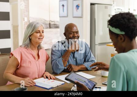 Ein älteres Paar, das mit einer afroamerikanischen Finanzberaterin spricht Stockfoto