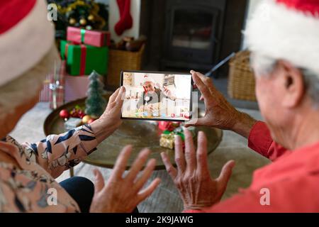 Ein erfahrenes weißes Paar, das ein weihnachtliches Videogespräch mit einem erfahrenen Weißen führt Stockfoto