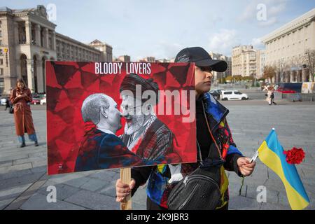 Kiew, Ukraine. 28. Oktober 2022. Eine Iranerin, die in der Ukraine lebt, hält ein Plakat mit den Ähnlichkeiten des russischen Präsidenten Wladimir Putin und des iranischen Obersten Führers Ali Khamenei während eines Protestes gegen die iranische Regierung und der Lieferung iranischer Drohnen an Russland im Zentrum von Kiew. Die ukrainischen Behörden sagten, dass etwa 400 Drohnen aus dem Iran von Russland bei mehr als 30 Drohnenangriffen auf die Ukraine eingesetzt wurden. Der Iran hat die Lieferung von Waffen an Russland für den Einsatz in der Ukraine verweigert. Kredit: SOPA Images Limited/Alamy Live Nachrichten Stockfoto