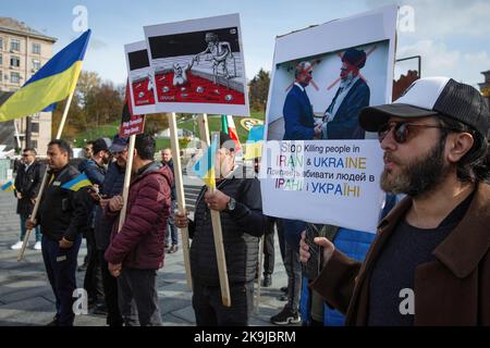 Kiew, Ukraine. 28. Oktober 2022. Iraner, die in der Ukraine leben, halten Plakate mit den Neigungen des russischen Präsidenten Wladimir Putin und des iranischen Obersten Führers Ali Khamenei während eines Protests gegen die iranische Regierung und der Lieferung iranischer Drohnen an Russland im Zentrum von Kiew. Die ukrainischen Behörden sagten, dass etwa 400 Drohnen aus dem Iran von Russland bei mehr als 30 Drohnenangriffen auf die Ukraine eingesetzt wurden. Der Iran hat die Lieferung von Waffen an Russland für den Einsatz in der Ukraine verweigert. Kredit: SOPA Images Limited/Alamy Live Nachrichten Stockfoto