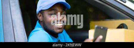 Afrikanischer Kurier der Lieferfirma hält ein Box-Paket und mit Smartphone im Auto mit Lächeln und happy.Concept of Business Delivery Service Stockfoto