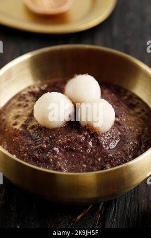 Patjuk, korean Red Bean Porridge mit Reiskuchen auf der Oberseite. Stockfoto