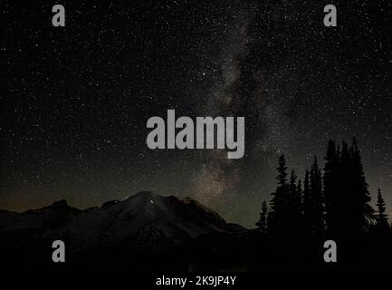 WA22625-00...WASHINGTON - die Milchstraße über Mount Rainier vom Sunrise Area im Mount Rainier National Park. Beachten Sie die Scheinwerfer der Kletterer als Stockfoto