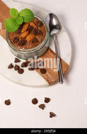 chia Pudding mit Schokolade und Mandeln auf weißem Tisch Stockfoto