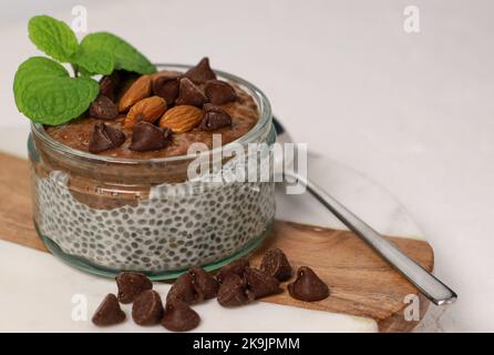 chia Pudding mit Schokolade und Mandeln auf weißem Tisch Stockfoto