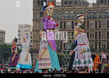 Mexiko-Stadt, Mexiko. 28. Oktober 2022. Menschenmassen versammeln sich um riesige Skulpturen von Catrina, der Skelett-Braut, während des Festivals Megaofrenda of Zocalo, um den Beginn des Tags der Toten auf der Plaza de la Constitucion am 28. Oktober 2022 in Mexiko-Stadt, Mexiko, zu feiern. Quelle: Richard Ellis/Richard Ellis/Alamy Live News Stockfoto