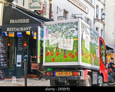 Paris Frankreich - 22 2009. Juni; malerischer Mohn-Lieferwagen an der gepflasterten Straße im Viertel Montmartre vor der Brasserie und dem Restaurant Stockfoto