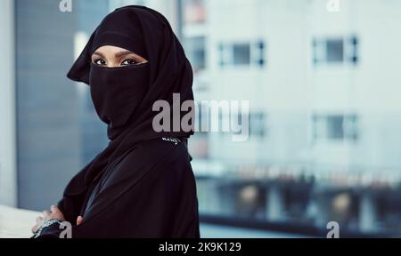 Ich mache mir diesen Arbeitsplatz zu eigen. Zugeschnittenes Porträt einer arabischen Geschäftsfrau in einer Burka, die in ihrem Büro steht. Stockfoto