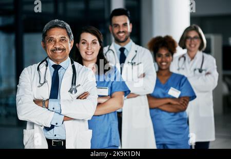 Wir stehen zusammen, um Sie besser zu machen. Porträt eines Teams von selbstbewussten Ärzten, die in einem Krankenhaus zusammenstehen. Stockfoto