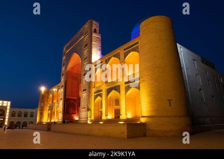 Nahaufnahme der mittelalterlichen mir-i-arabischen Madrasah in farbenfroher Nachtbeleuchtung. Buchara, Usbekistan Stockfoto