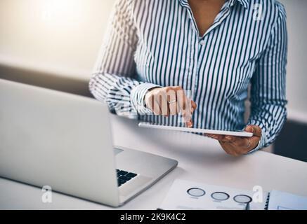 Erfolg wird mit einem Fingerwisch erzielt. Nahaufnahme einer unkenntlichen Geschäftsfrau, die in einem Büro an einem digitalen Tablet arbeitet. Stockfoto