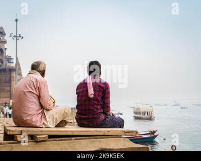 Zwei Männer plaudern vor dem Fluss ganges in varanasi indien Stockfoto