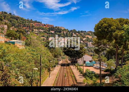 Die Hügel von Roquebrune Cap Martin bei Monaco an der Mittelmeerküste, Südfrankreich, mit den Bahngleisen, die weg führen Stockfoto