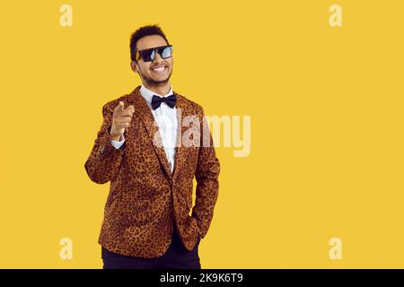 Glücklicher schwarzer Mann in der Jacke zeigen auf den Bildschirm Stockfoto