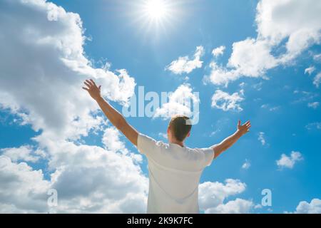 Der Mensch strebe die Hände nach dem tiefblauen Himmel und der Sonne. Religion und konzeptuelle Szene. Anbetung vor Gott. Stockfoto