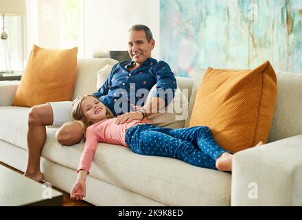 Sie bedeutet mir die Welt. Porträt eines reifen Mannes und seiner Tochter auf dem Sofa zu Hause. Stockfoto