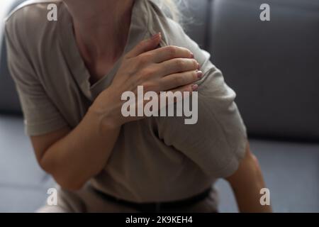 Zarte Frauenhand am Hals isoliert auf weißem Hintergrund: medizinisches Konzept Stockfoto