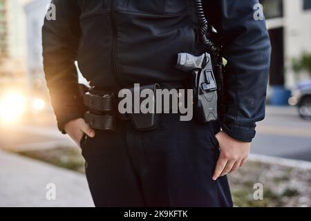 Es ist am besten, wenn Sie im Dienst sind, entspannt zu bleiben. Nahaufnahme eines nicht erkennbaren Polizisten auf der Patrouille. Stockfoto