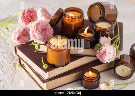Ein Set verschiedener Duftkerzen in braunen Glasgefäßen. Handgemachte Duftkerze. Sojalkerzen brennen in einem Glas. Aromatherapie und entspannen Sie sich im Spa und zu Hause. Feuer in braunem Glas. Stockfoto