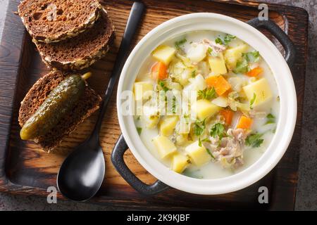 Zupa Ogorkowa Gurkensuppe ist eine traditionelle polnische und litauische Suppe, die aus sauren, gesalzenen Gurken und Wurzelgemüse in der Nähe des Topfes auf dem besteht Stockfoto