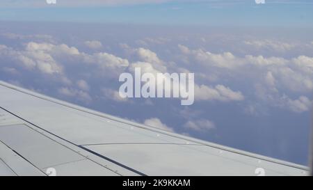 Flügel eines Flugzeuges, Ansicht des Passagiers. Blick durch das Fenster eines Flugzeugs auf seinen glänzenden Flügel Stockfoto