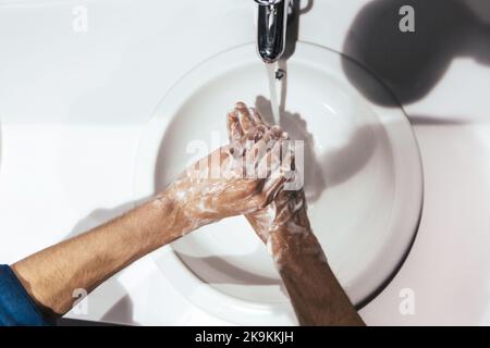 Nahaufnahme. Der Mensch wäscht sich vorsichtig die Hände mit Seife Stockfoto