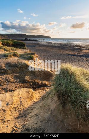 Schönes Landschaftsbild im Sommer bei Sonnenuntergang von Widemouth Bay in Devon England mit goldenem Stundenlicht am Strand Stockfoto