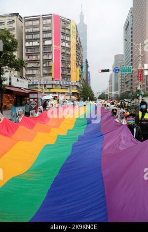 Taipeh, Taiwan. 29. Oktober 2022. Die riesige Regenbogenfahne in den Straßen von Taipei bei der Taipei LGBT Pride Parade, Taipei, Taiwan. Der 20.. Jahrestag der Parade fand trotz Regen statt und die Teilnehmer trotzten den Elementen meist mit Regenschirmen, was aber die Stimmung und den Spaß nicht dämpfte. Zehntausende nahmen an der Parade Teil, die auf einem Rundweg vom Rathaus von Taipei im Schatten von Taiwans höchstem Gebäude, Taipei 101, stattfand. Kredit: Paul Brown/Alamy Live Nachrichten Stockfoto