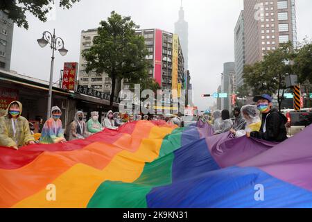 Taipeh, Taiwan. 29. Oktober 2022. Die riesige Regenbogenfahne in den Straßen von Taipei bei der Taipei LGBT Pride Parade, Taipei, Taiwan. Der 20.. Jahrestag der Parade fand trotz Regen statt und die Teilnehmer trotzten den Elementen meist mit Regenschirmen, was aber die Stimmung und den Spaß nicht dämpfte. Zehntausende nahmen an der Parade Teil, die auf einem Rundweg vom Rathaus von Taipei im Schatten von Taiwans höchstem Gebäude, Taipei 101, stattfand. Kredit: Paul Brown/Alamy Live Nachrichten Stockfoto