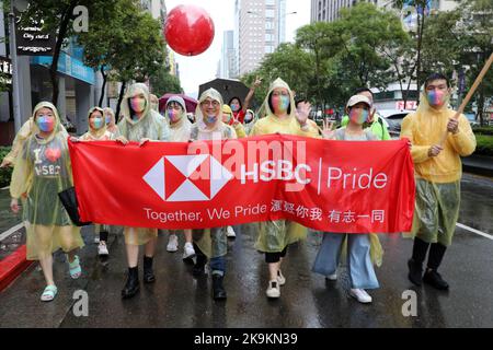 Taipeh, Taiwan. 29. Oktober 2022. Teilnehmer von HSBC vertreten Geschäftsinteressen an der Taipei LGBT Pride Parade, Taipei, Taiwan. Der 20.. Jahrestag der Parade fand trotz Regen statt und die Teilnehmer trotzten den Elementen meist mit Regenschirmen, was aber die Stimmung und den Spaß nicht dämpfte. Zehntausende nahmen an der Parade Teil, die auf einem Rundweg vom Rathaus von Taipei im Schatten von Taiwans höchstem Gebäude, Taipei 101, stattfand. Kredit: Paul Brown/Alamy Live Nachrichten Stockfoto