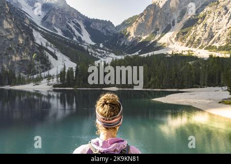 Beschreibung: Die junge Frau genießt am Morgen eine herrliche Aussicht auf den Pragser See in den Dolomiten. Pragser Wildsee, Pragser See, Pragser See, Dolo Stockfoto