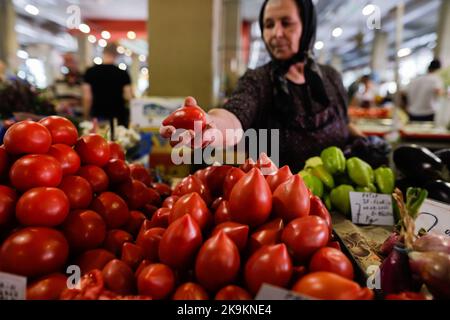 Bukarest, Rumänien - 4. August 2022: Details zur geringen Schärfentiefe (selektiver Fokus) mit einer älteren Frau, die Gemüse an einem Stand auf dem Obor-Markt verkauft Stockfoto