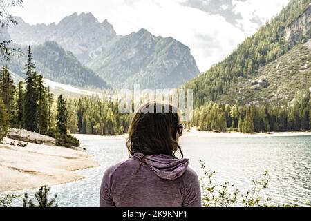 Beschreibung: Die junge Frau genießt am Nachmittag eine wunderschöne Aussicht auf den Baires-See in den Dolomiten. Pragser Wildsee, Pragser See Stockfoto